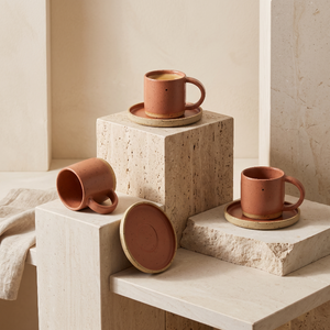 Trzy zestawy HU.KA Sorso na trawertynowych bryłach, jeden spodek ustawiony pionowo