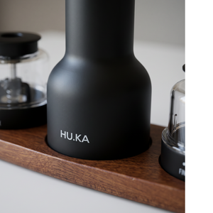 Detal HU.KA Pulse Premium Wood — matowy czarny korpus z logotypem na podstawce